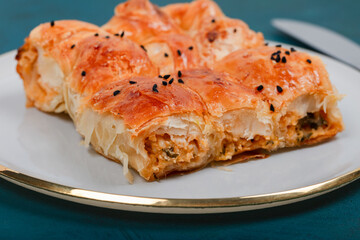 Plate of Turkish Cheese Borek with Fork and Knife – Flaky Pastry with Sesame Seeds, Ideal for Traditional Turkish Cuisine and Mediterranean Food Presentations