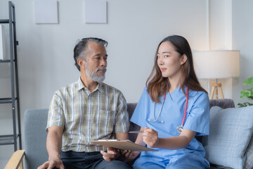 Young female doctor explains medical test results to her senior patient on a couch, showing compassion and professionalism in healthcare