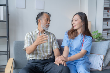 Female doctor is reassuring a senior male patient during a home visit, demonstrating empathy and...