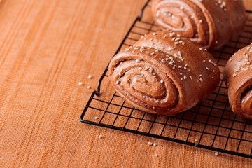 Korvapuusti, traditional finnish cinnamon and cardamom rolls, fresh baked buns on the metal grid, sweet dessert Sweden and Finland