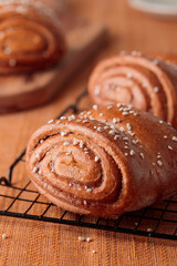 Korvapuusti, traditional finnish cinnamon and cardamom rolls, fresh baked buns on the metal grid, sweet dessert Sweden and Finland