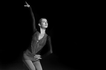 woman figure skater posing on dark background