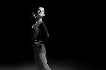 woman figure skater posing on dark background © zhagunov_a