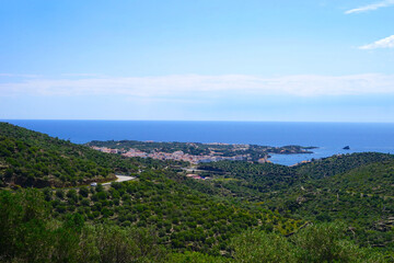 Obraz premium view from the hills to the village Cadaqués at the Mediterranean Sea, landscape with hills and trees, Catalonia, Spain
