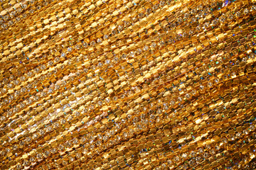 Gold lace with rhinestones shimmers, creating an impression of luxurious texture. Perfect for background or concept of elegance and wealth. Suitable for topics about fashion, jewelry, designer details