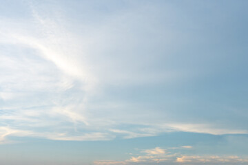 Obraz premium Beautiful cloudscape painted in hues of blue and white, casting long shadows on the vast ocean as the sun dips below the horizon