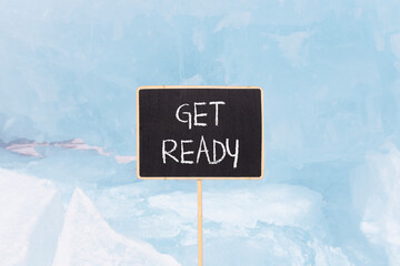 Get ready symbol. Concept words Get ready on beautiful yellow black blackboard. Beautiful blue ice background. Business, support, motivation and get ready concept. Copy space.