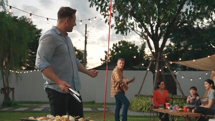 Family camp in garden, Father help old couple grill food for family member. Outdoor camping...