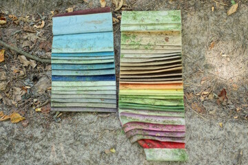 two row of colored fabric samples lie gray ground in the street