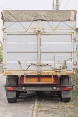 part of a container on a truck with gray closed metal doors with iron latches on the street