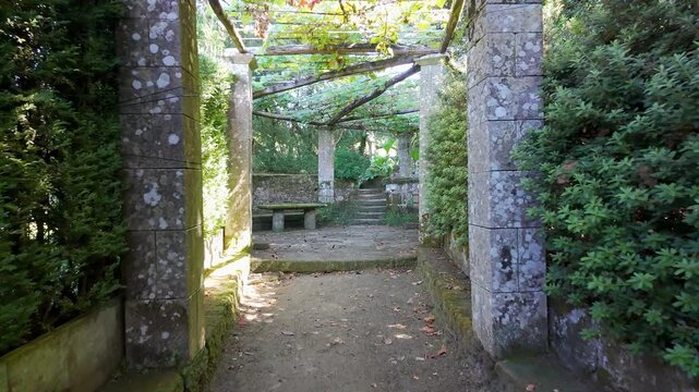 Path through lush vegetation that leads to a decorative stone structure, Pazo de Oca, Galicia.