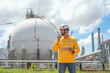 portrait refinery worker wears safety and harthat using walkie talkie communicate with team while inspection in oil refinery industry