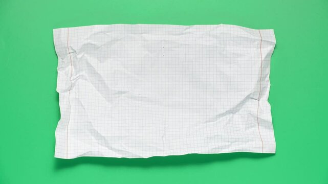 Stop motion animation of crumpled paper on a green background.