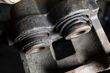 Old caliper brake piston has oil stains and the rubber is torn. The car brake system needs repair