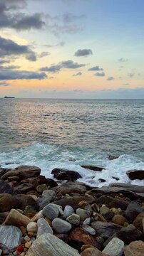 Slow motion of waves breaking on the rocks on a tropical beach at sunset. Macuto Coast, Venezuela.