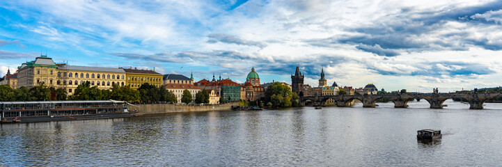 Prague, Czech Republic amazing panoramic view. World famous heritage Charles Bridge, medieval stone arch bridge that crosses the Vltava river. Bridge and embankment at autumn sunny day. 