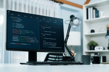 Programming code on computer screen desktop placing on working desk showing intelligent website development coder system running database online with information technology design concept. Infobahn.