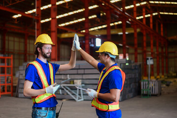 Happy team engineer giving high five after successful work. Factory  engineer  touching hands with co worker after finish work and Completed the work perfectly, The project is progressing as planned.