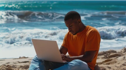 Athletic African American man working on a laptop at the beach
