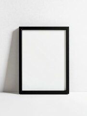 A minimalist black photo frame on a plain white background with soft shadows, highlighting clean lines and elegance.