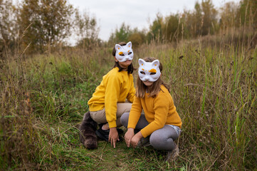 child girl in an animal mask in a cat mask plays quadrober