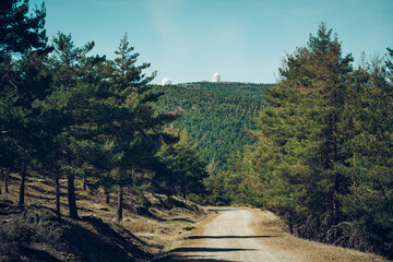 footpath in the forest of pine trees with the astronomical observatory of astronomy in the...
