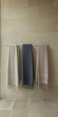 Fototapeta premium Soft, neutral towels hanging neatly in a serene bathroom setting with stone walls