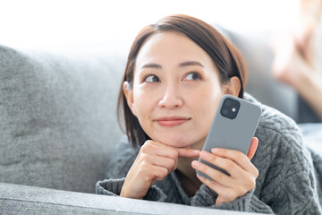 悩む女性・スマホ