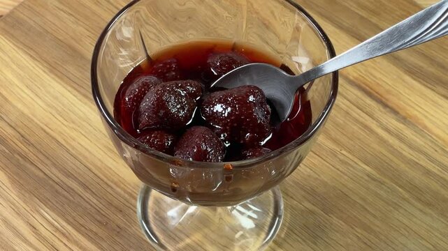 Strawberry jam with whole berries in dessert bowl with spoon