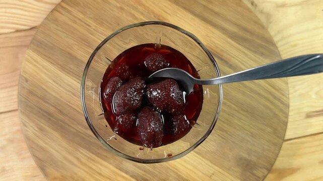 Strawberry jam with whole berries in dessert bowl with spoon