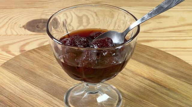 Strawberry jam with whole berries in dessert bowl with spoon