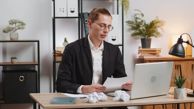 Caucasian businessman writes business idea paperwork writing stress with mistake lack of inspiration rips sheet of paper from notebook throw away. Sad unhappy freelancer writer guy crumpling notes.