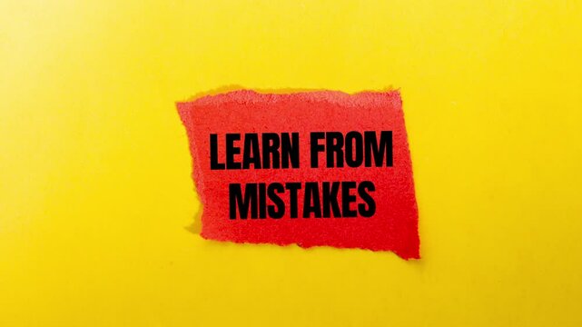 Learn from mistakes message writing on ripped torn red paper piece on yellow background. Conceptual learn from mistakes symbol.