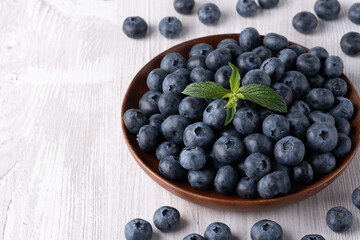 Fresh blueberries on a wooden white table, with copy space for text