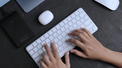 a woman is studying online in front of a computer with her hands typing on the keyboard