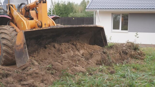 wheel loader working on the construction of a house in the countryside