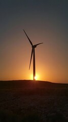 Obraz premium Wind turbine at sunset with silhouette view