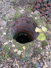 An old brick well overgrown with moss