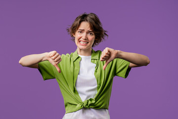Pretty woman with sign of dislike. Grimacing condemning lady showing thumbs-down