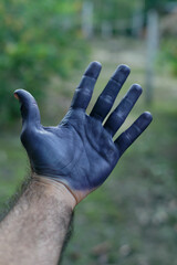Hands painted in blue with genipa fruit extract