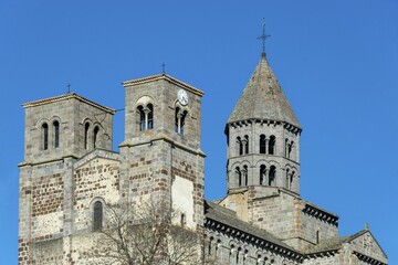 Romanesque church of Saint Nectaire, Puy de Dome departement, Auvergne-Rhone-Alpes, France, blue sky, bricks, Europe