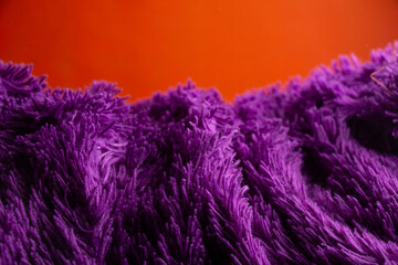 purple downy blanket or soft wavy wool texture on orange background