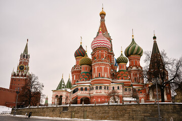 Fototapeta premium MOSCOW, RUSSIA - JANUARY 23rd 2024: Moscow's Red Square comes alive on a frosty day. Golden decor, snowy paths, and Christmas markets create a serene winter scene among historical landmarks.