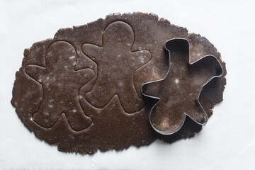 top view of gingerbread cookie dough, Overhead view of cut out molasses cookie dough on a marble countertop, process of making christmas cookies