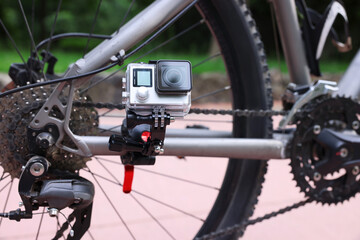 Obraz premium Modern action camera with mount on bicycle outdoors, closeup