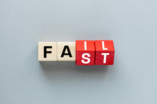 FAIL and FAST concept. letters on wooden blocks changing the word fast to fail, concept, beautiful gray background. flat lay, copy space