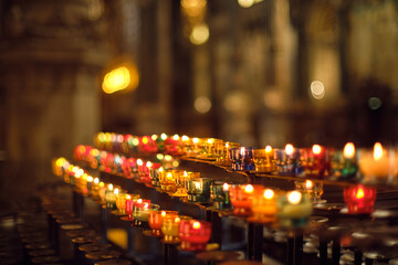 colorful candles lit inside french church in Lyon