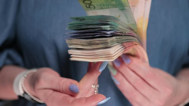 Female hands holding paper bills Belarusian rubles