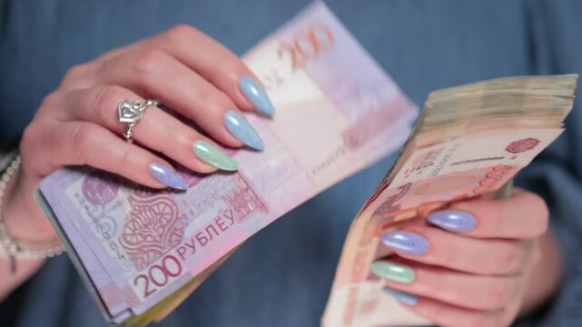 Female hands holding paper bills Belarusian rubles
