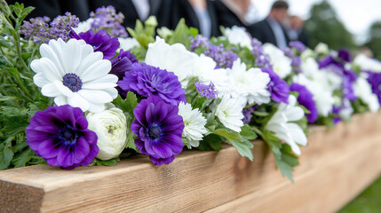 White and purple floral arrangement on coffin during funeral procession.